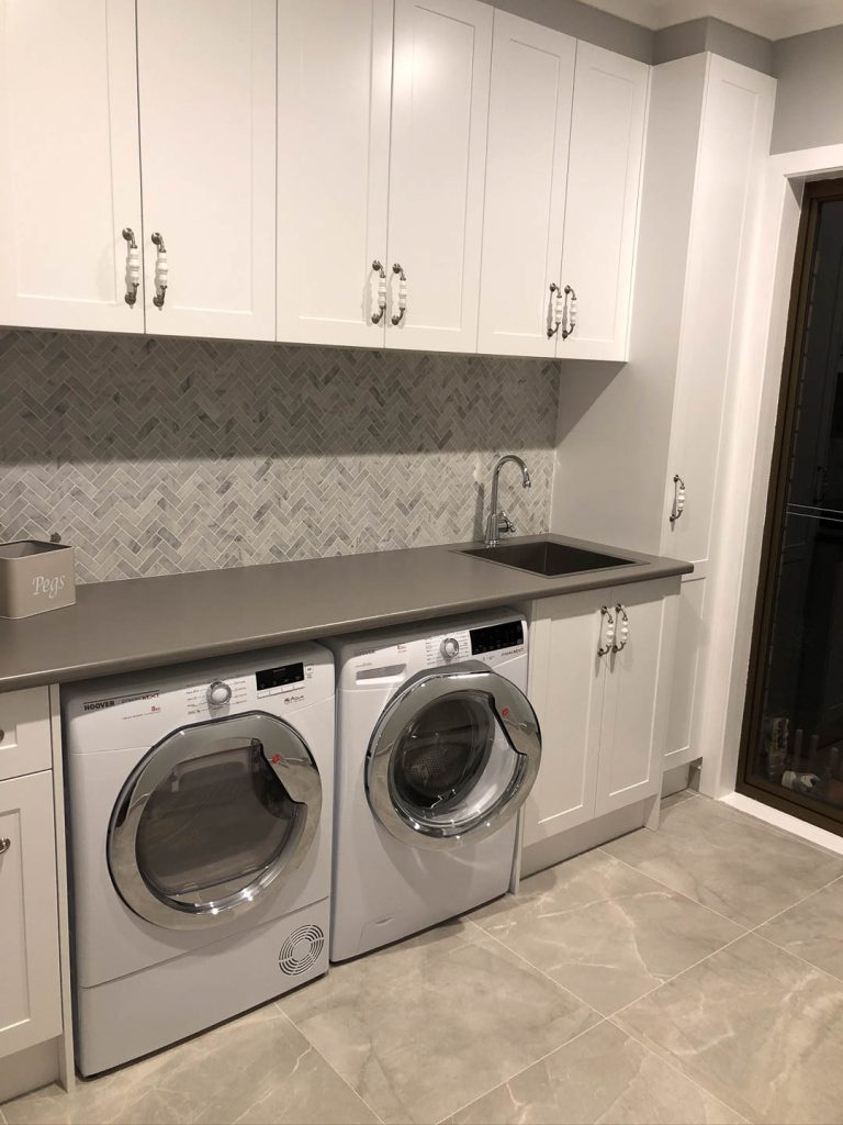 Custom laundry cabinetry with practical storage and bench space